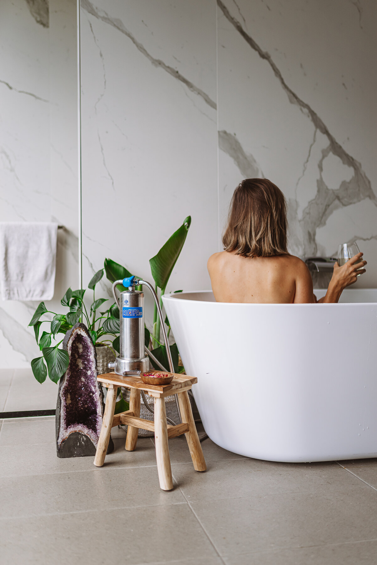 Enagic Anespa DX shower filter in a spa-style bathroom